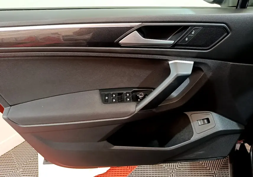 Vue rapprochée de la porte avant gauche noire du Volkswagen Tiguan 2.0 TDI 150 DSG7 Life Business avec commandes électriques.