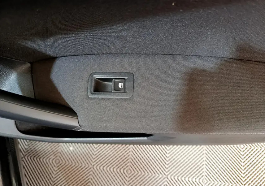 Bouton de verrouillage de porte sur la garniture intérieure noire de la porte côté gauche d'un Volkswagen Tiguan 2021.