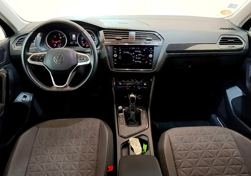 Intérieur du Volkswagen Tiguan 2.0 TDI 2021 vu de face, tableau de bord noir avec écran tactile central et volant cuir.