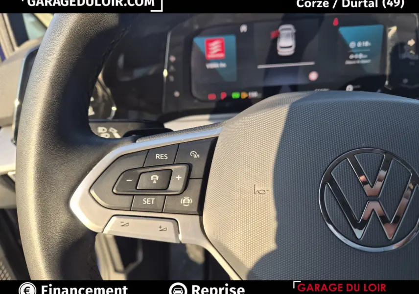 Gros plan sur le volant cuir gris de la Volkswagen Golf 2023 avec commandes multifonctions et logo VW central.