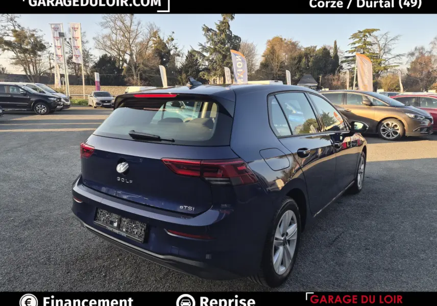Vue 3/4 arrière droite d'une Volkswagen Golf bleu nuit 2023 avec feux arrière LED et jantes alliage.