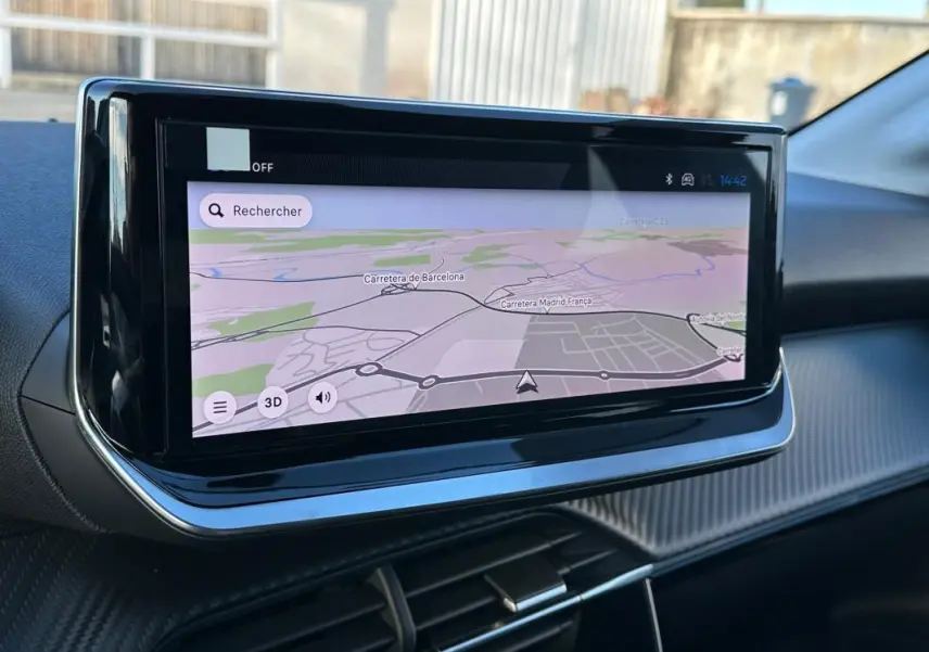 Écran tactile de navigation intégré au tableau de bord d'une Peugeot 208 Hybrid 110 blanc, vue intérieure.