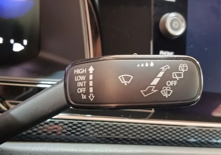 Gros plan sur la manette de commande des essuie-glaces dans l’habitacle du Volkswagen Taigo gris foncé 2023.