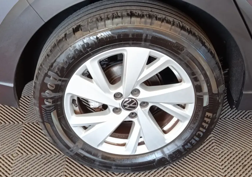 Gros plan sur la roue avant gauche de la Volkswagen Taigo gris foncé avec jante alliage à 5 branches doubles.
