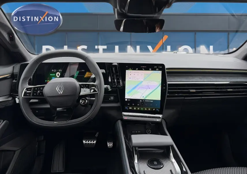 Vue intérieure frontale du tableau de bord du Renault Austral gris schiste avec écran tactile vertical et volant multifonction.