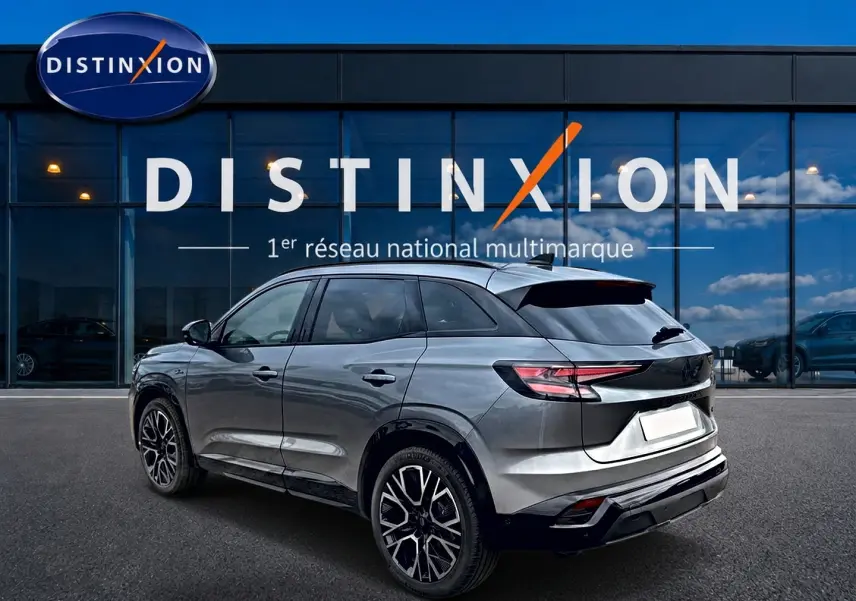 Renault Austral gris schiste en 3/4 arrière droit, avec jantes alu noires et toit noir brillant devant vitrine Distinxion.