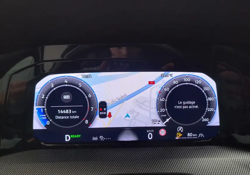 Tableau de bord numérique de Volkswagen Golf 1.5 eTSI 2025 affichant la navigation et compteurs, vue frontale intérieure.