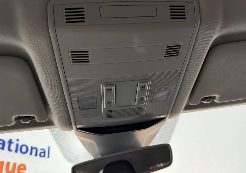 Vue intérieure du plafonnier gris avec commandes d'éclairage et rétroviseur dans un Volkswagen T-Roc blanc 2020.