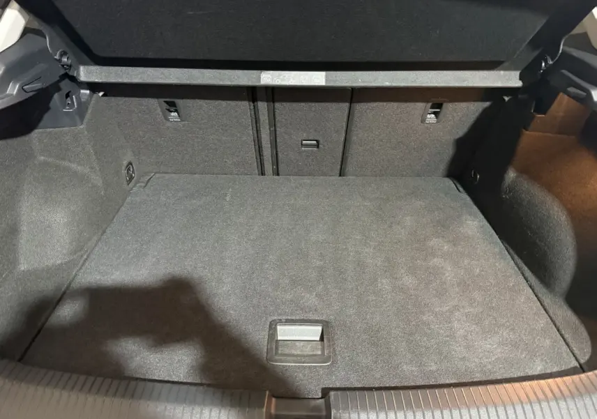 Coffre ouvert du Volkswagen T-Roc blanc 2020, montrant un espace de chargement propre et bien fini en tissu noir.