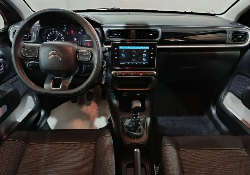 Vue intérieure avant du Citroën C3 gris foncé 2024, volant multifonctions, écran tactile central et boîte manuelle.