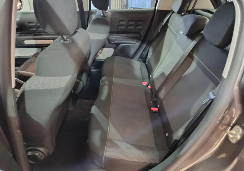 Vue intérieure côté droit sur la banquette arrière gris foncé de la Citroën C3 2024 avec ceintures et appuie-têtes.