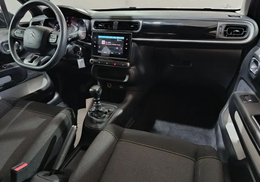 Vue intérieure côté conducteur de la Citroën C3 gris foncé 2024, avec tableau de bord tactile et volant multifonctions.
