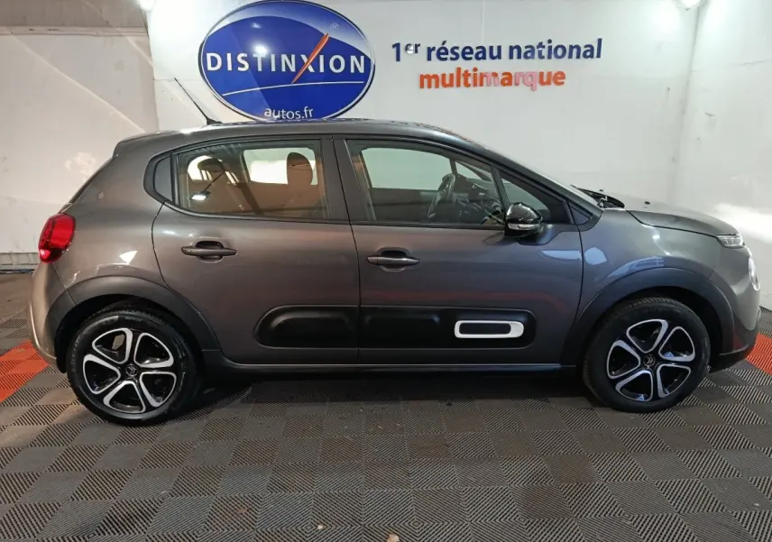 Profil droit d'une Citroën C3 2024 gris foncé avec protections latérales noires et jantes alliage distinctives.