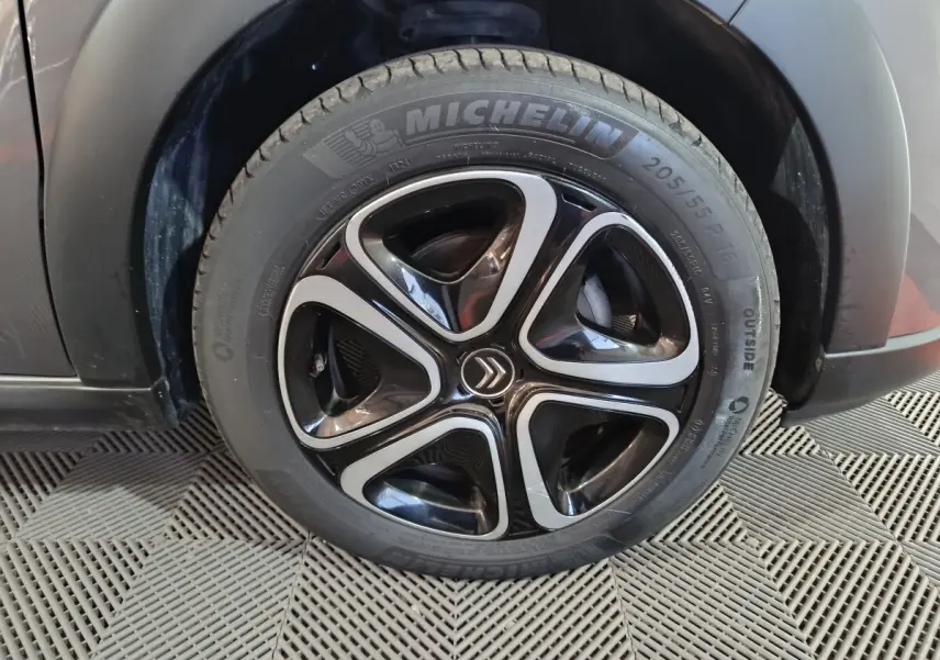 Gros plan sur la roue avant gauche gris foncé d’une Citroën C3 2024 avec jante noire et argentée au design triangulaire.