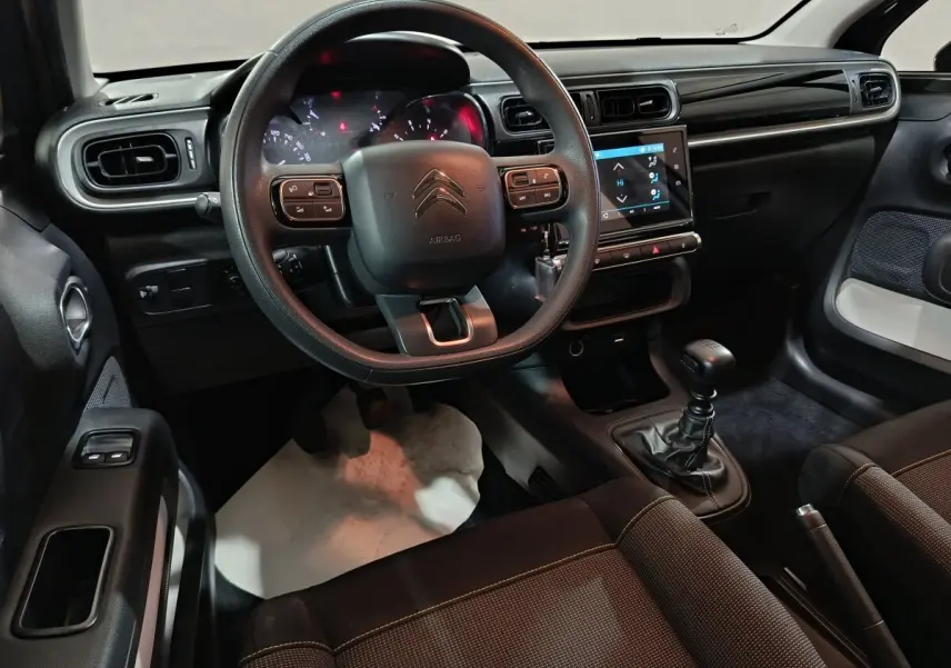 Vue intérieure avant de la Citroën C3 2024, volant multifonctions, tableau de bord tactile et levier de vitesse manuel.