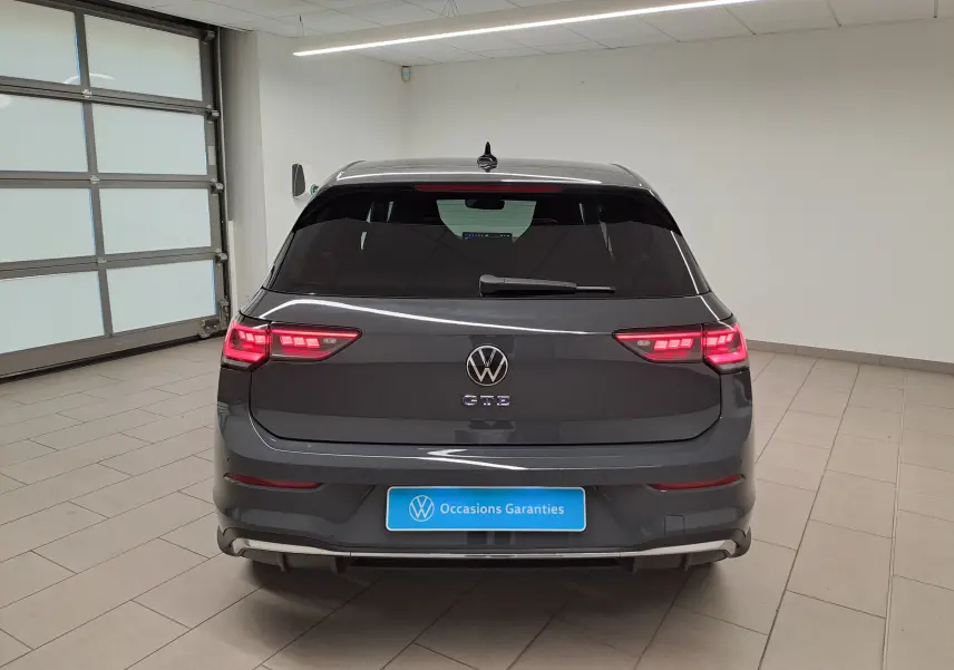 Vue arrière d'une Volkswagen Golf 1.5 eHybrid 272 DSG6 GTE 2025 en gris Urano avec feux LED allumés en intérieur.