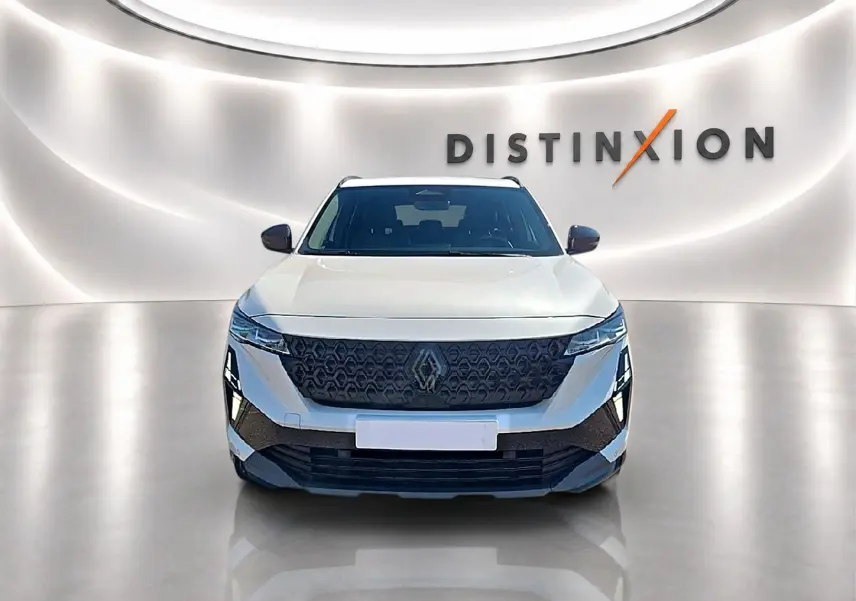 Vue avant d'un Renault Austral blanc nacré avec calandre noire et phares LED dans un showroom lumineux.