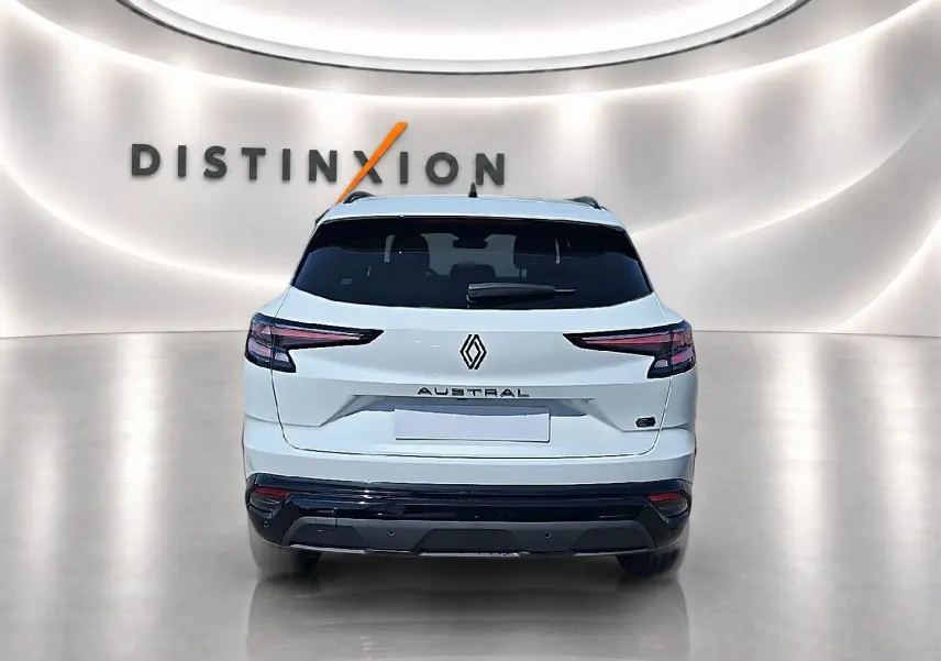 Vue arrière d’un Renault Austral blanc nacré avec feux arrière LED et logo distinctif sur fond lumineux "Distinxion".