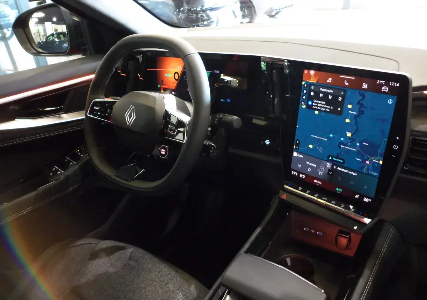 Intérieur du Renault Rafale E-Tech 2025, vue du poste de conduite avec volant multifonction et grand écran tactile central.