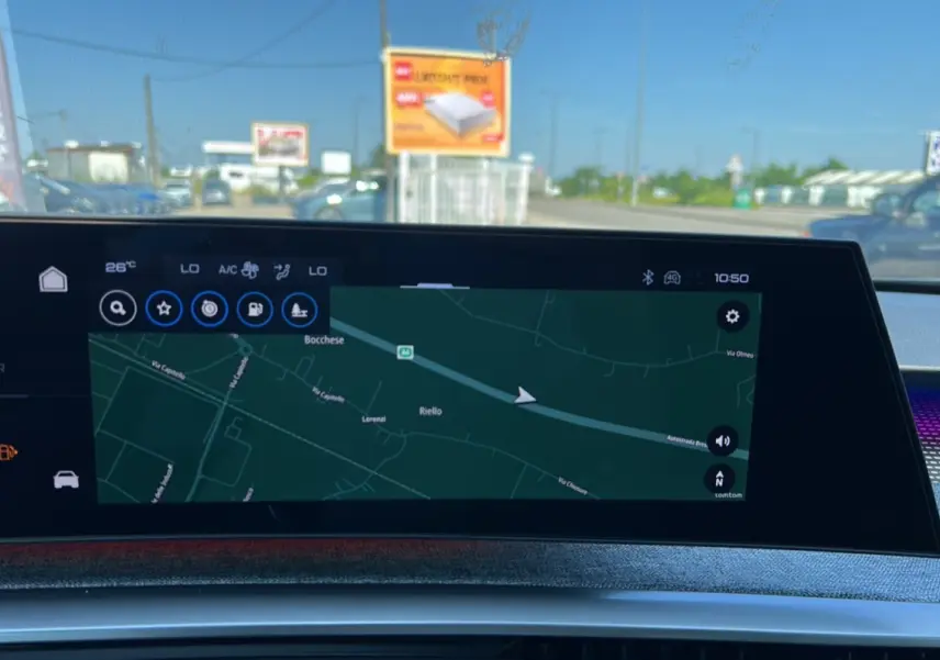 Écran tactile du tableau de bord du Peugeot 3008 Hybrid 2025 affichant la navigation GPS en extérieur lumineux.