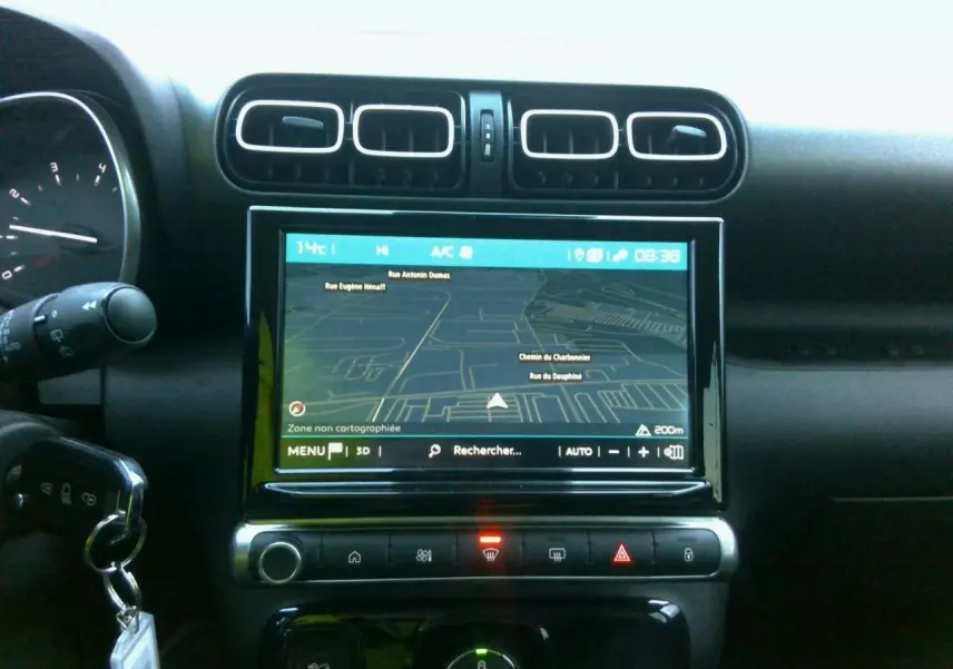 Vue rapprochée de l’écran central tactile avec navigation GPS dans l’habitacle noir du Citroën C3 Aircross gris foncé.
