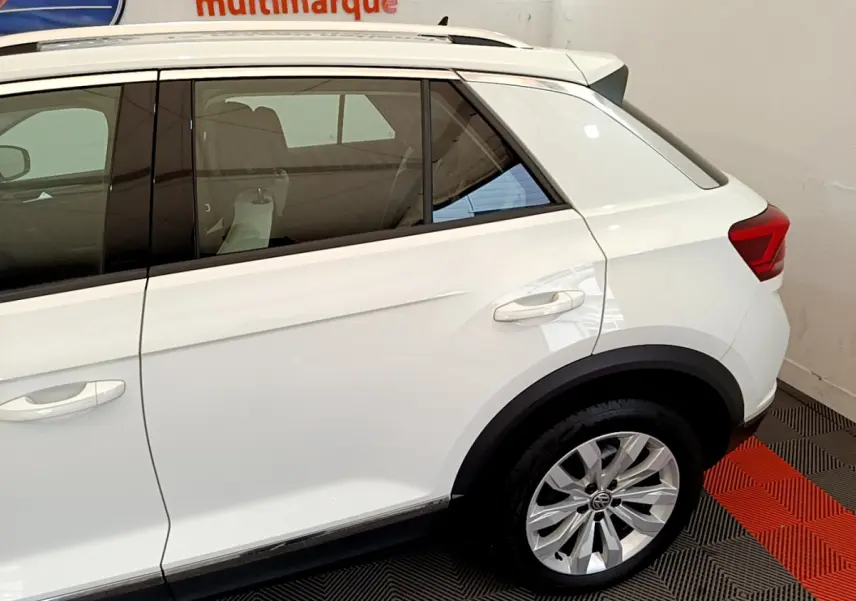 Vue latérale côté droit du Volkswagen T-Roc blanc 2020, mettant en valeur la porte arrière et la roue arrière en alliage.