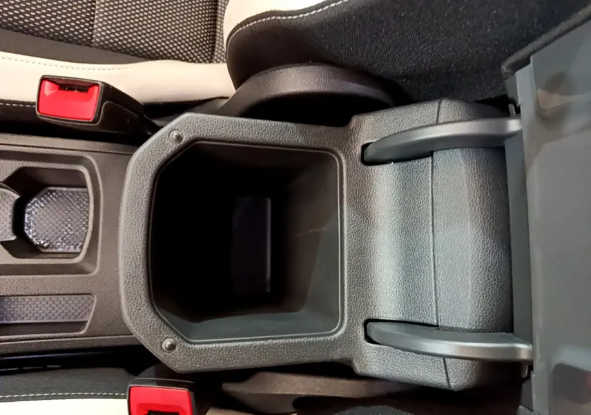 Gros plan sur le rangement central ouvert entre les sièges avant noir et blanc du Volkswagen T-Roc blanc 2020.