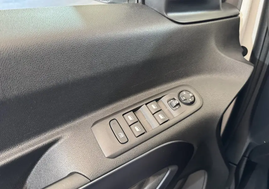 Gros plan sur la commande des vitres et rétroviseurs côté conducteur du Peugeot Rifter blanc, version 2019.