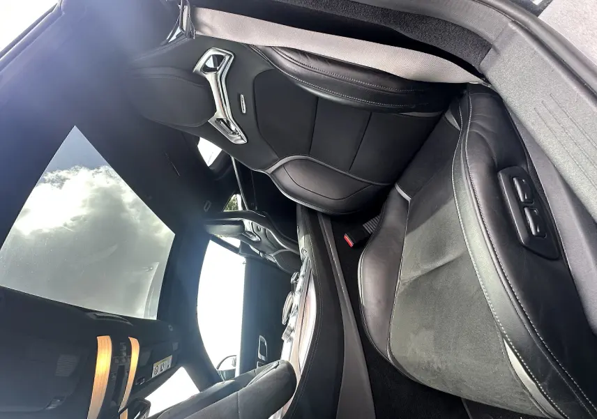 Intérieur du Mercedes AMG GT 2015 vu côté droit, sièges sport noirs en cuir et alcantara avec surpiqûres blanches.