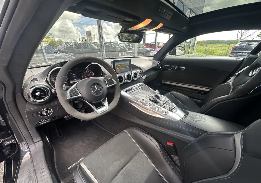 Intérieur noir de la Mercedes AMG GT 2015 vu côté conducteur, avec volant sport et console centrale alu.