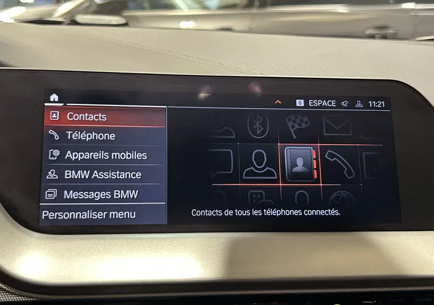 Écran central de la BMW Série 1 16d 2023 affichant le menu contacts avec interface moderne et fond noir.
