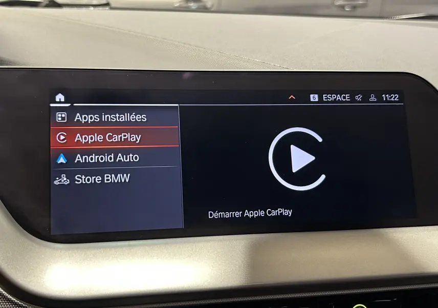 Écran central tactile de BMW Série 1 16d 2023 affichant le menu Apple CarPlay en intérieur clair.