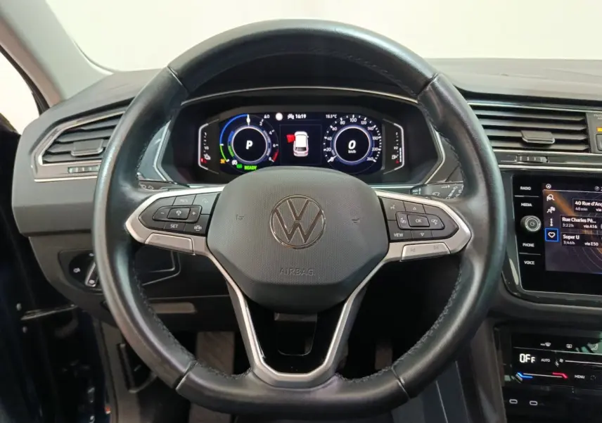 Volant cuir noir et tableau de bord numérique du Volkswagen Tiguan hybride rechargeable 2022 vu de face intérieure.