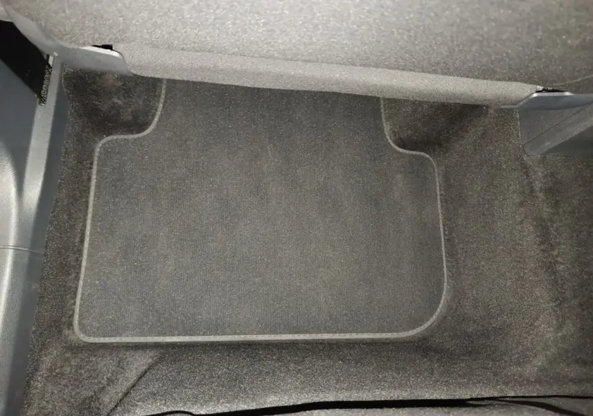 Tapis de sol noir dans l'habitacle avant du Volkswagen Tiguan 1.4 eHybrid 2022, vue plongeante.