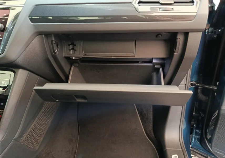 Gant de rangement ouvert côté passager dans l'habitacle du Volkswagen Tiguan bleu 2022 hybride rechargeable.