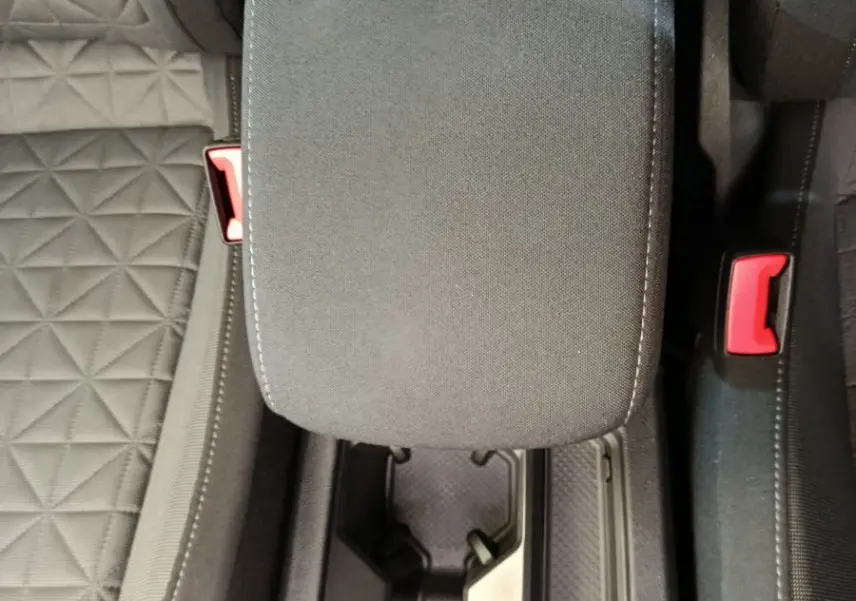 Gros plan sur la console centrale noire avec accoudoir et porte-gobelets du Volkswagen Tiguan hybride rechargeable 2022.