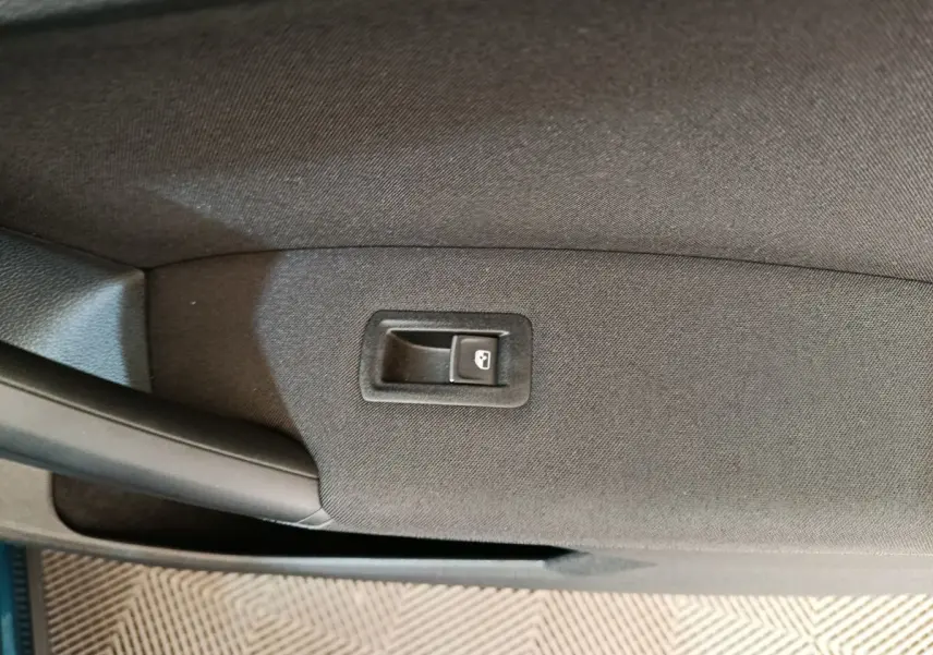 Bouton de verrouillage des portes sur la garniture intérieure noire de la porte côté gauche du Volkswagen Tiguan hybride rechargeable bleu.