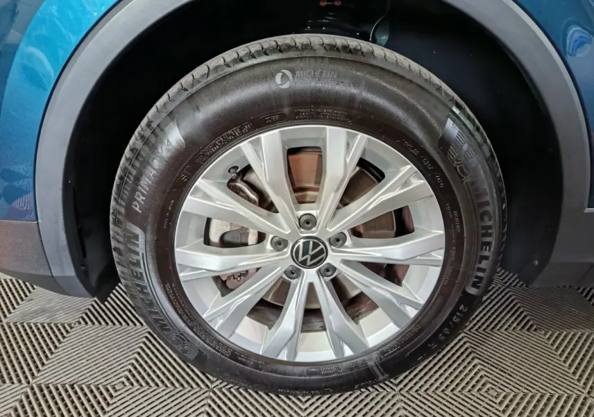 Gros plan sur la roue avant gauche d'un Volkswagen Tiguan bleu 2022 avec jante alliage et pneu Michelin
