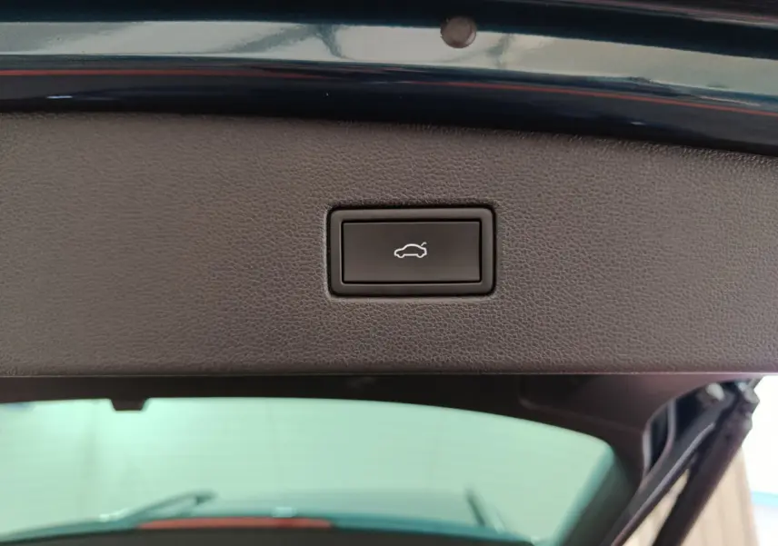 Bouton d'ouverture électrique du coffre sur le hayon intérieur d'un Volkswagen Tiguan bleu 2022 hybride rechargeable.
