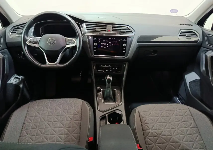 Intérieur du Volkswagen Tiguan 1.4 eHybrid 2022, vue frontale du tableau de bord et sièges gris à motifs géométriques.