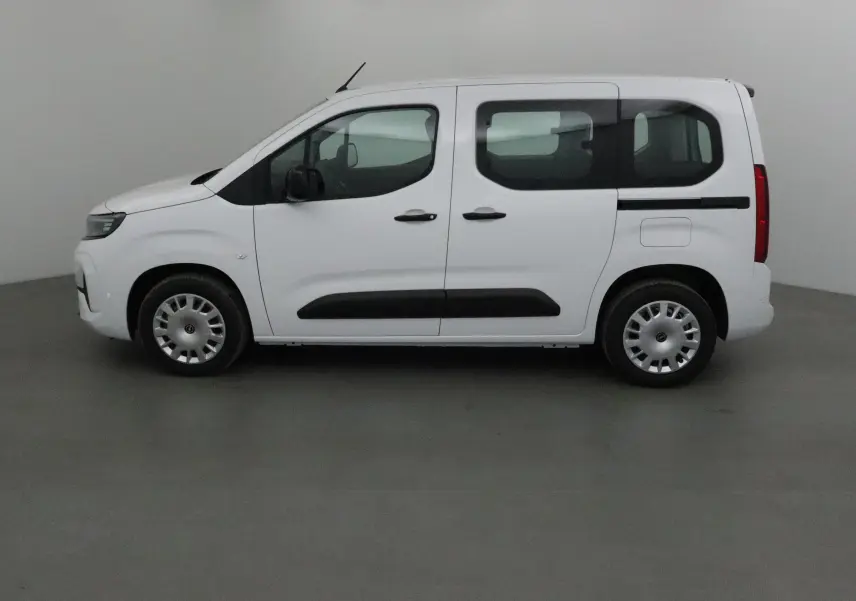 Profil côté gauche d'un Opel Combo Life blanc avec portes coulissantes et jantes acier, sur fond neutre intérieur.