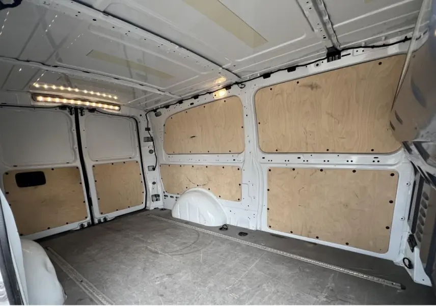 Vue intérieure arrière du fourgon blanc Mercedes Vito Extra Long 2021, avec habillage bois et plancher gris.