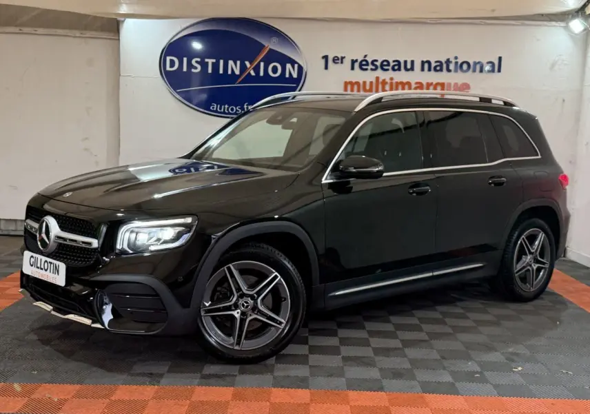 Mercedes GLB 200 d AMG Line noir vu de 3/4 avant droit, avec jantes AMG et barres de toit chromées visibles.