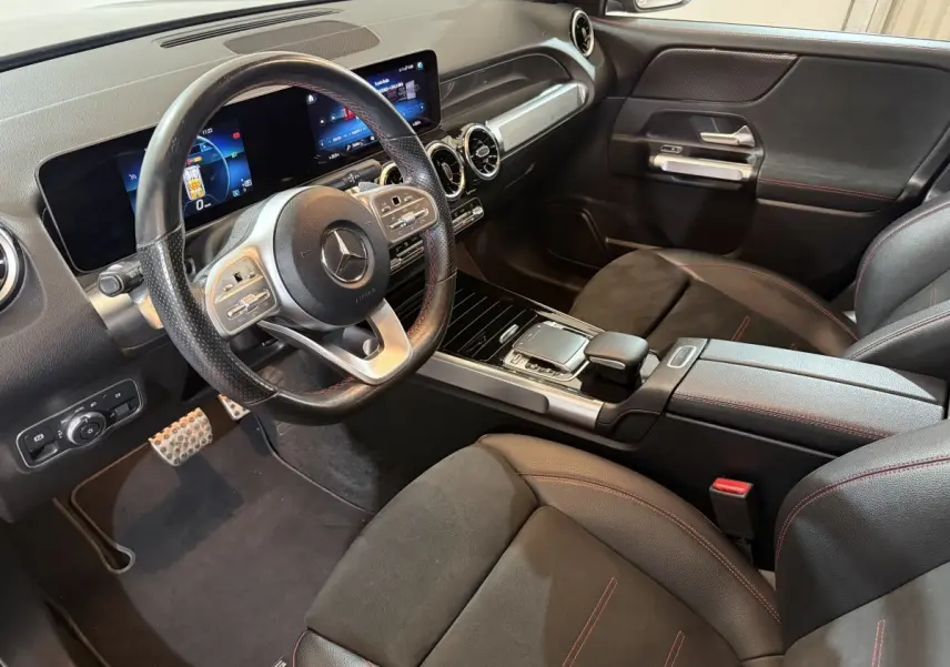 Intérieur noir du Mercedes GLB 200 d AMG Line 2020, vue côté conducteur sur volant cuir, tableau de bord digital et console centrale.