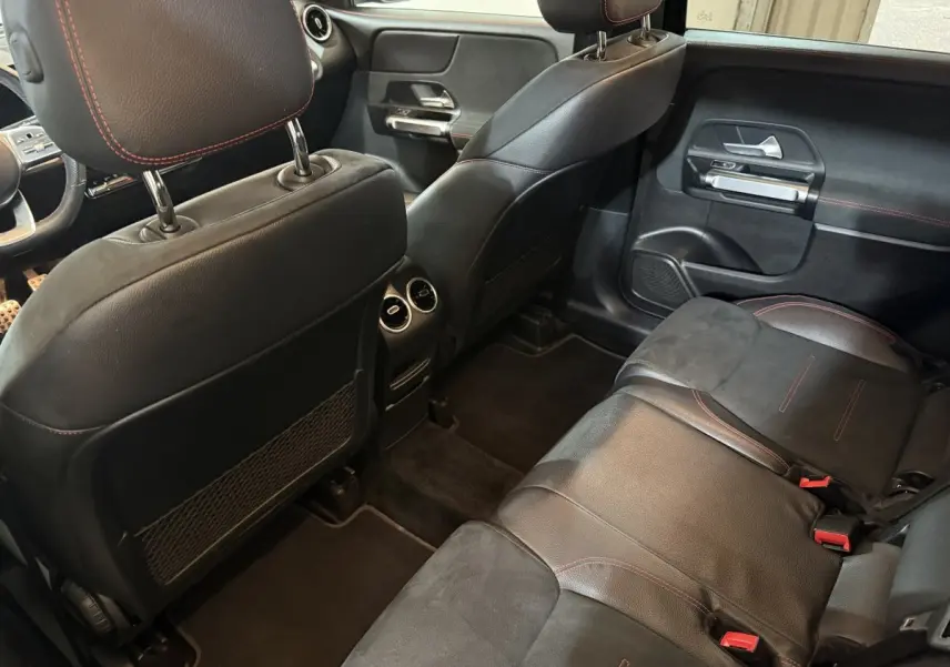 Vue intérieure arrière côté droit du Mercedes GLB 200 d AMG Line 2020 avec sièges en cuir noir et surpiqûres rouges.