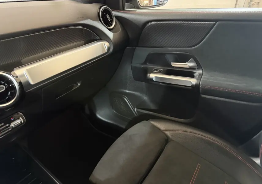 Intérieur côté passager du Mercedes GLB 200 d AMG Line noir, avec siège en alcantara et inserts aluminium sur la porte.