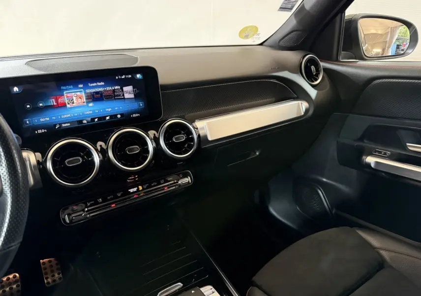 Intérieur du Mercedes GLB 200 d AMG Line 2020, vue du tableau de bord côté passager avec écran tactile et aérateurs ronds chromés.