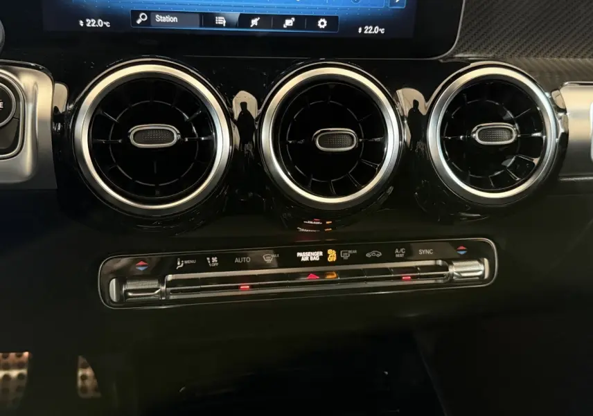 Vue rapprochée du tableau de bord noir du Mercedes GLB 200 d AMG Line 2020, avec aérateurs ronds et commandes climatisation.