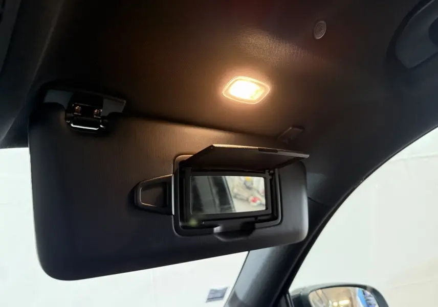 Miroir de courtoisie ouvert sur pare-soleil côté gauche dans l’habitacle noir du Mercedes GLB 200 d AMG Line 2020.