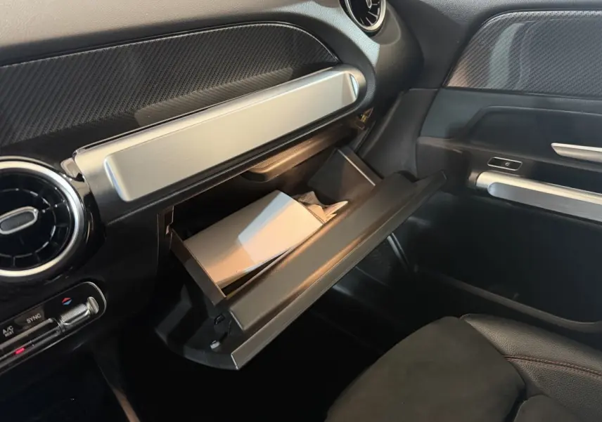 Intérieur noir du Mercedes GLB 200 d AMG Line 2020, vue côté passager avec boîte à gants ouverte et détails argentés.